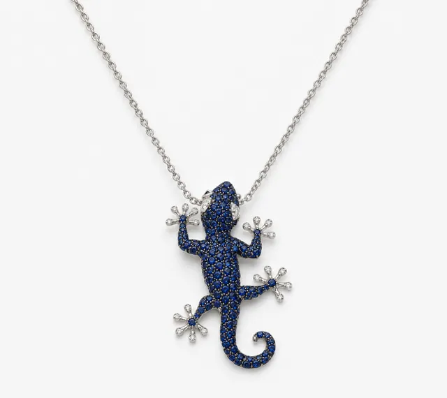 Scopri la nostra raffinata collana a forma di geco in oro bianco 18kt, impreziosita da intensi zaffiri naturali e luminosi diamanti. Un design unico per uno stile ricercato.
