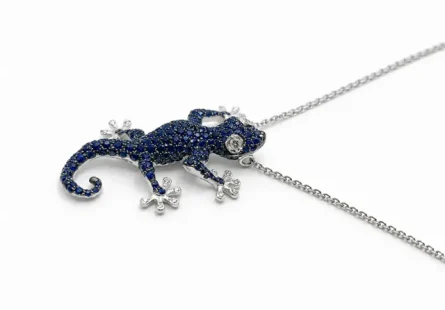 Scopri la nostra raffinata collana a forma di geco in oro bianco 18kt, impreziosita da intensi zaffiri naturali e luminosi diamanti. Un design unico per uno stile ricercato.